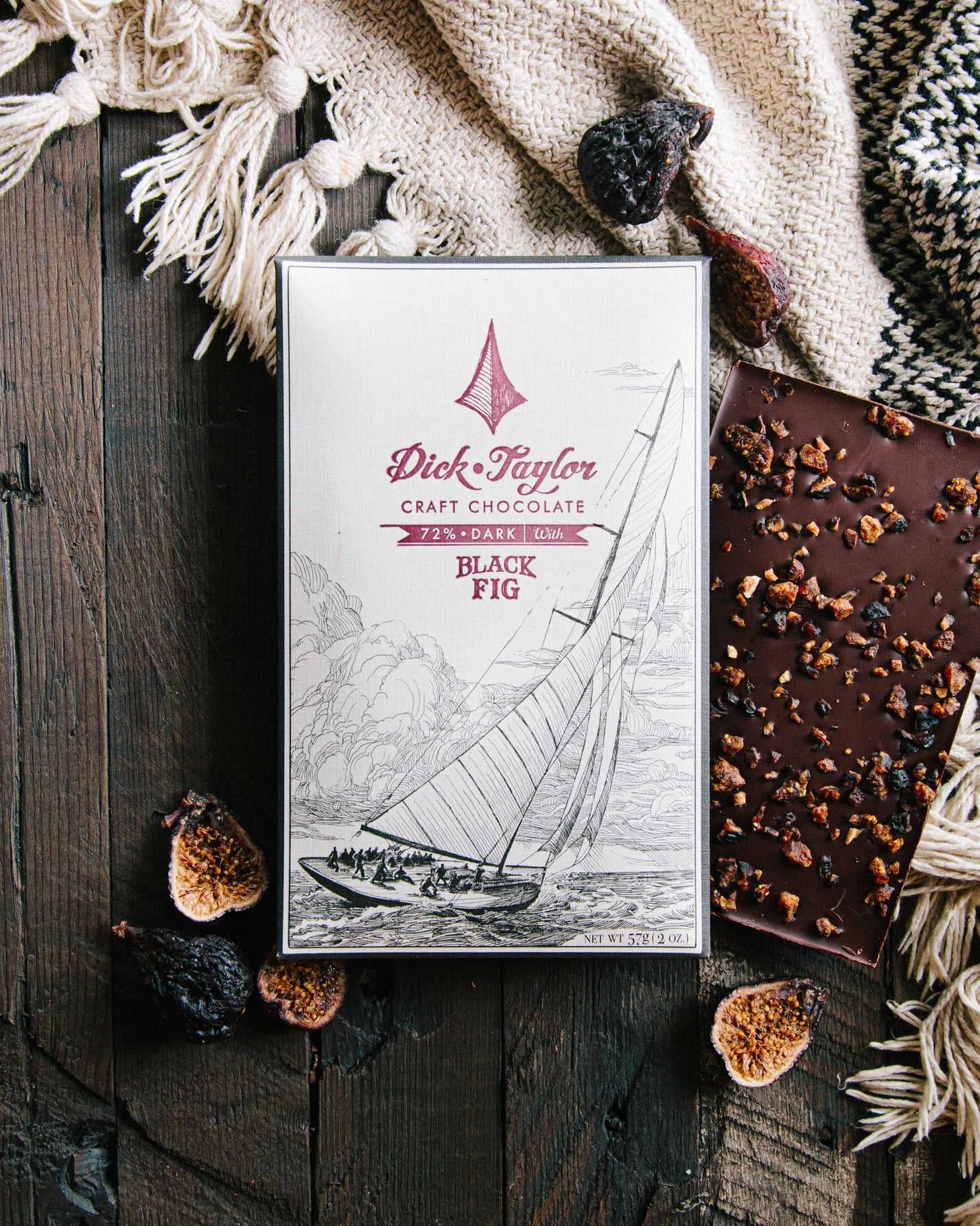 Dick Taylor craft chocolate bar with 'Black Fig' flavor on a wooden surface.