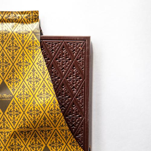 Chocolate bar with decorative gold packaging on a white background