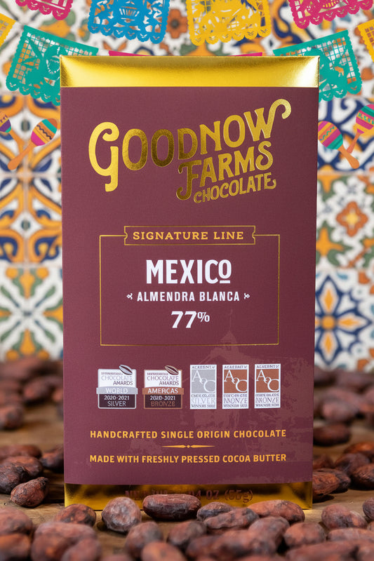 Goodnow Farms chocolate packaging with a blurred background of cocoa beans