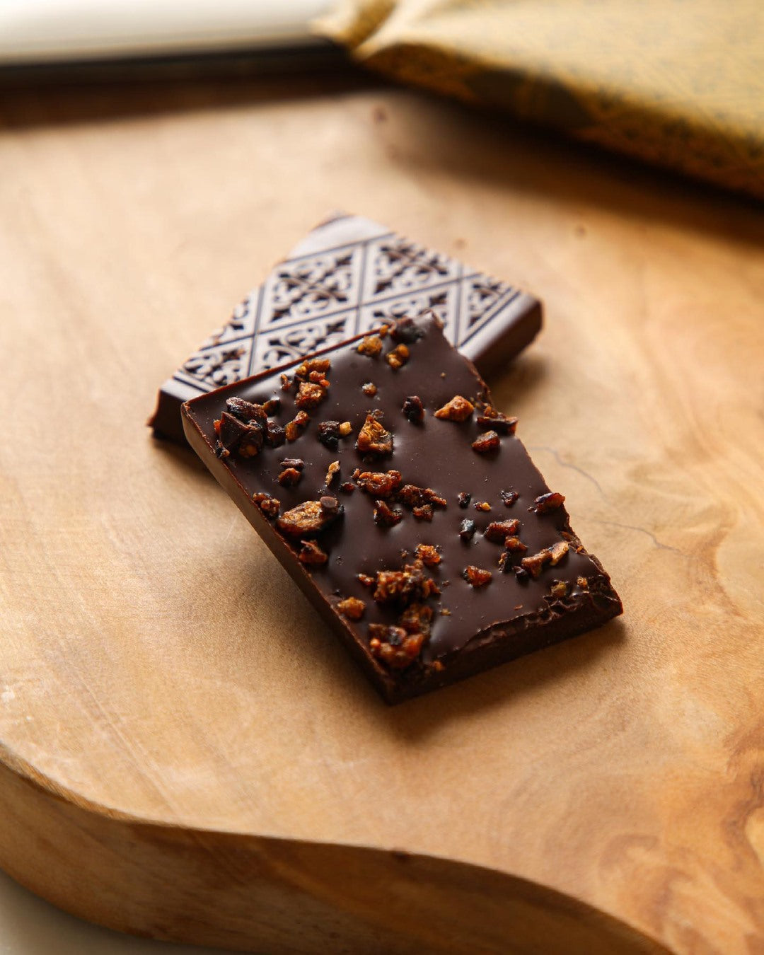 Chocolate bar with crumbly topping on a wooden surface